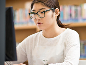 international student typing on a laptop